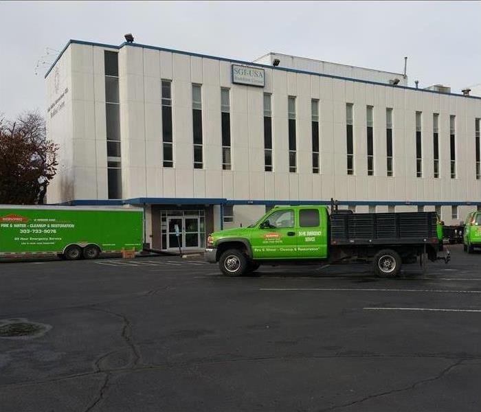 SERVPRO vehicles arriving to a building
